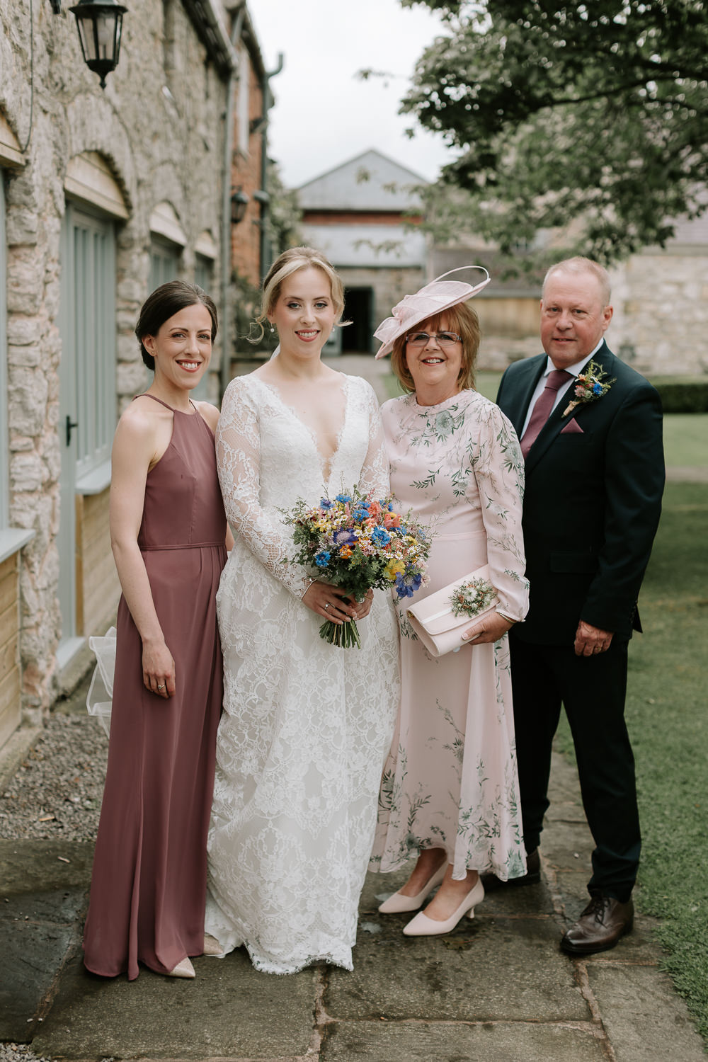 Wedding party posing outside cottages at Faenol Fawr