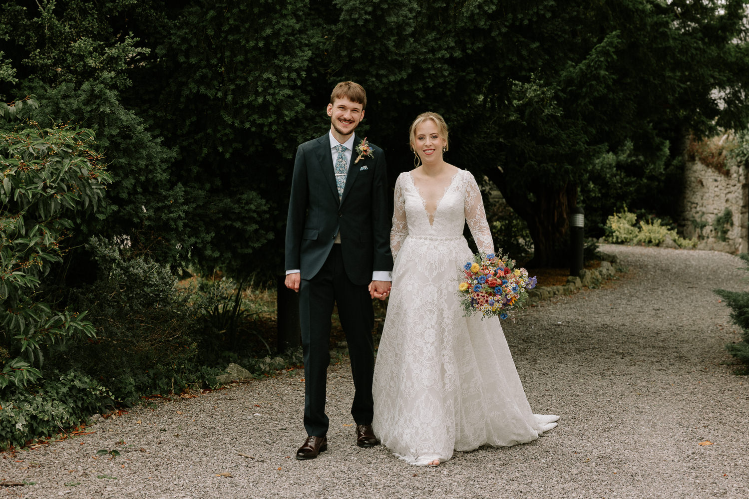 Bride and groom holding hands outdoors in Faenol Fawr