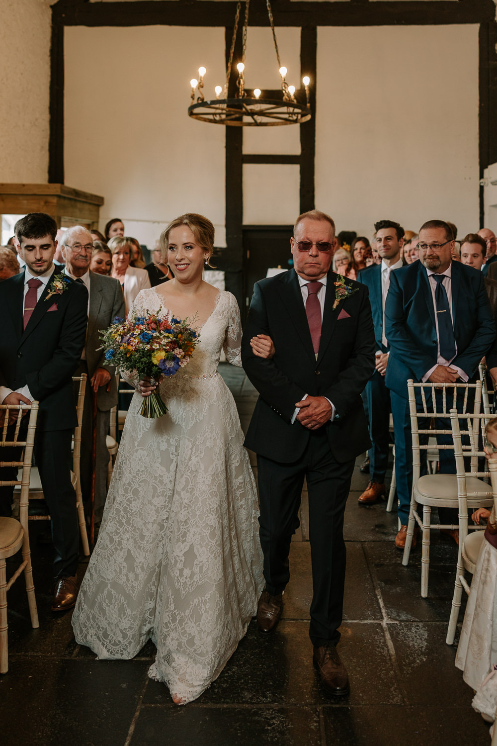 Bride walking down the aisle in the barn at Faenol Fawr