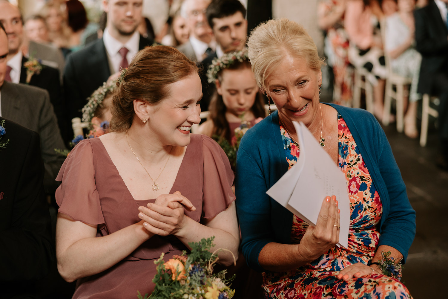 Two women enjoying a wedding ceremony.