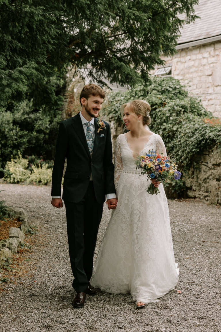 Couple walking hand in hand outdoors at Faenol Fawr