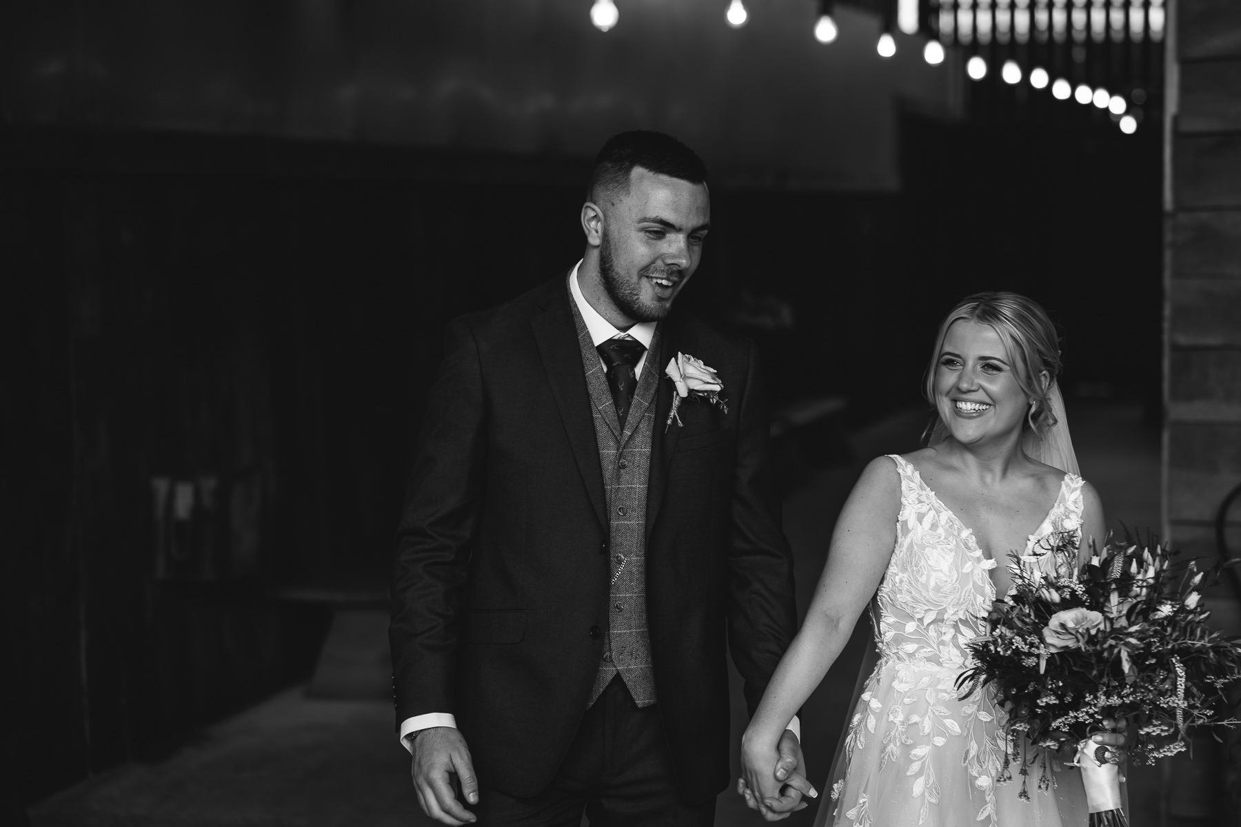 Bride smiling holding hands with groom
