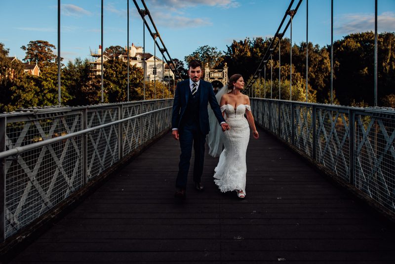 wedding couple walking on bridge