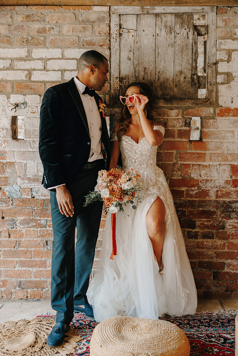wedding photograph of bride with glasses looking at groom