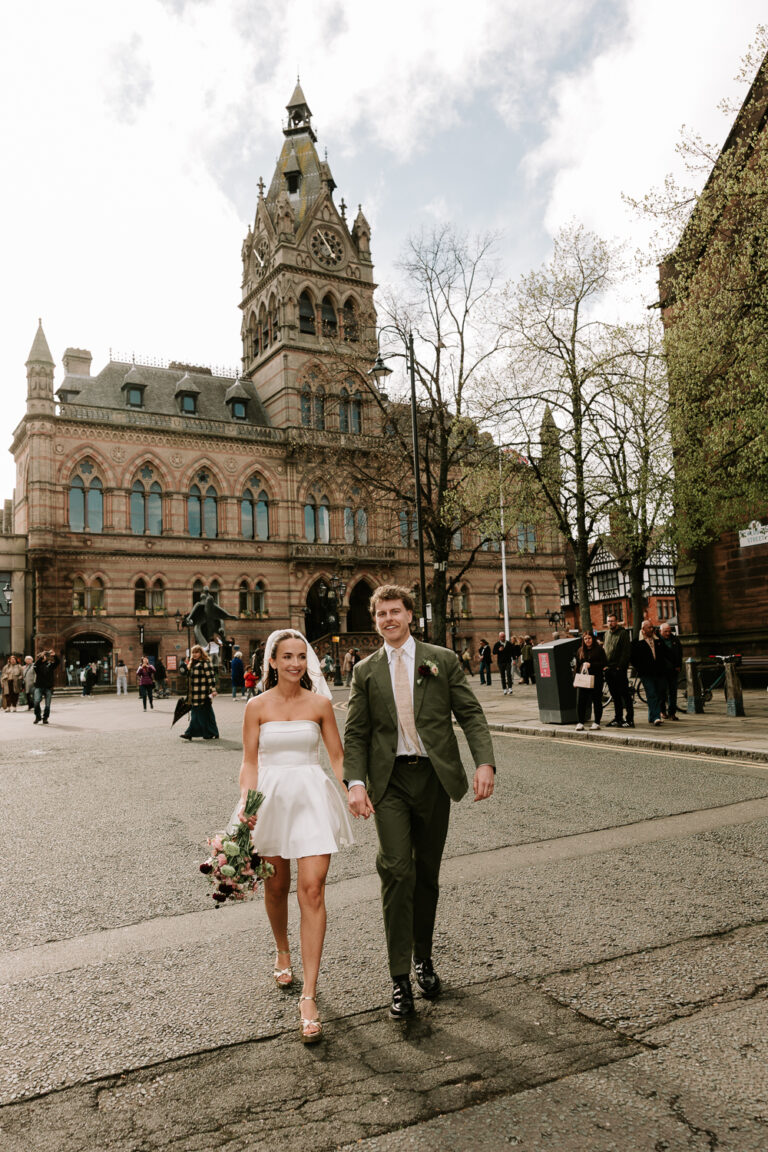Newlywed couple walking in front of Chester Town Hall